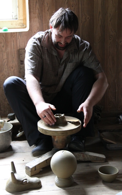 Adrian throwing clay.
